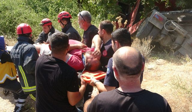 Antalya'da kum yüklü çekici dereye devrildi! Sürücüyü ağaç kurtardı